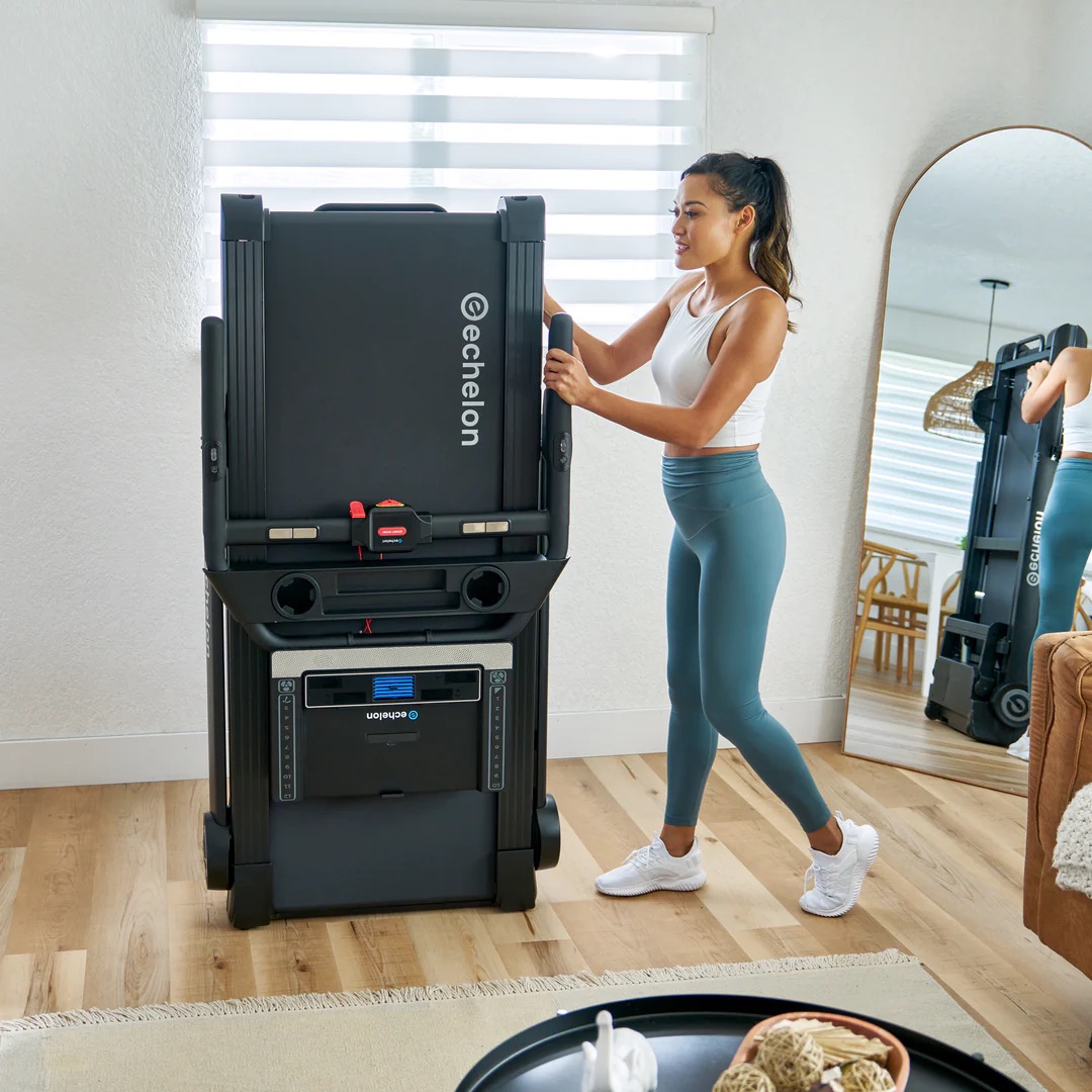 A woman exercising with a foldable echelon rowing machine at home.