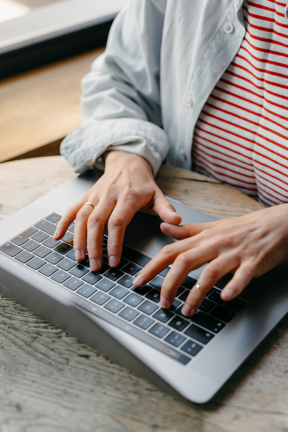 Close up of a person typing on a laptop.